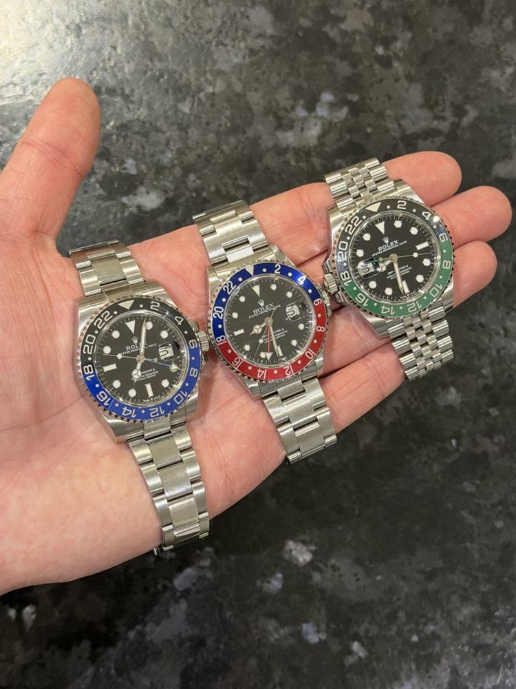 Trois montres de luxe en main